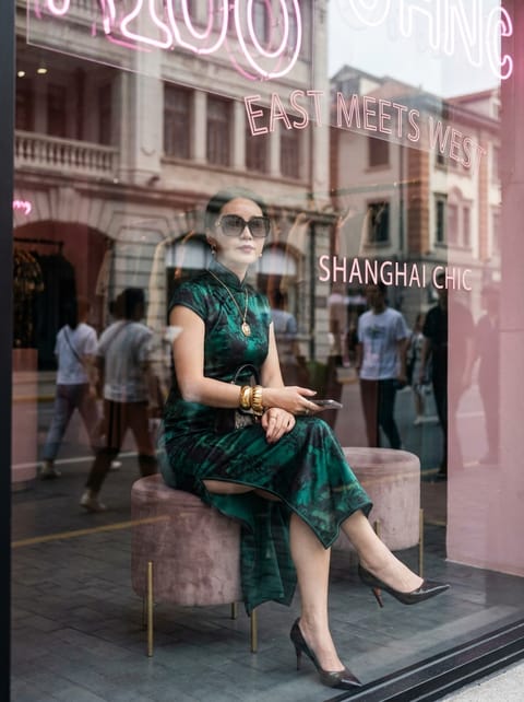 SKIPIKS AI时尚大片 — elegant, vintage — 绿色的中国风连衣裙优雅的氛围被感性地表达出来。搭配金色配饰和黑色高跟鞋，增添精致的点缀。这个造型推荐作为秋季城市中的时尚日常装扮。