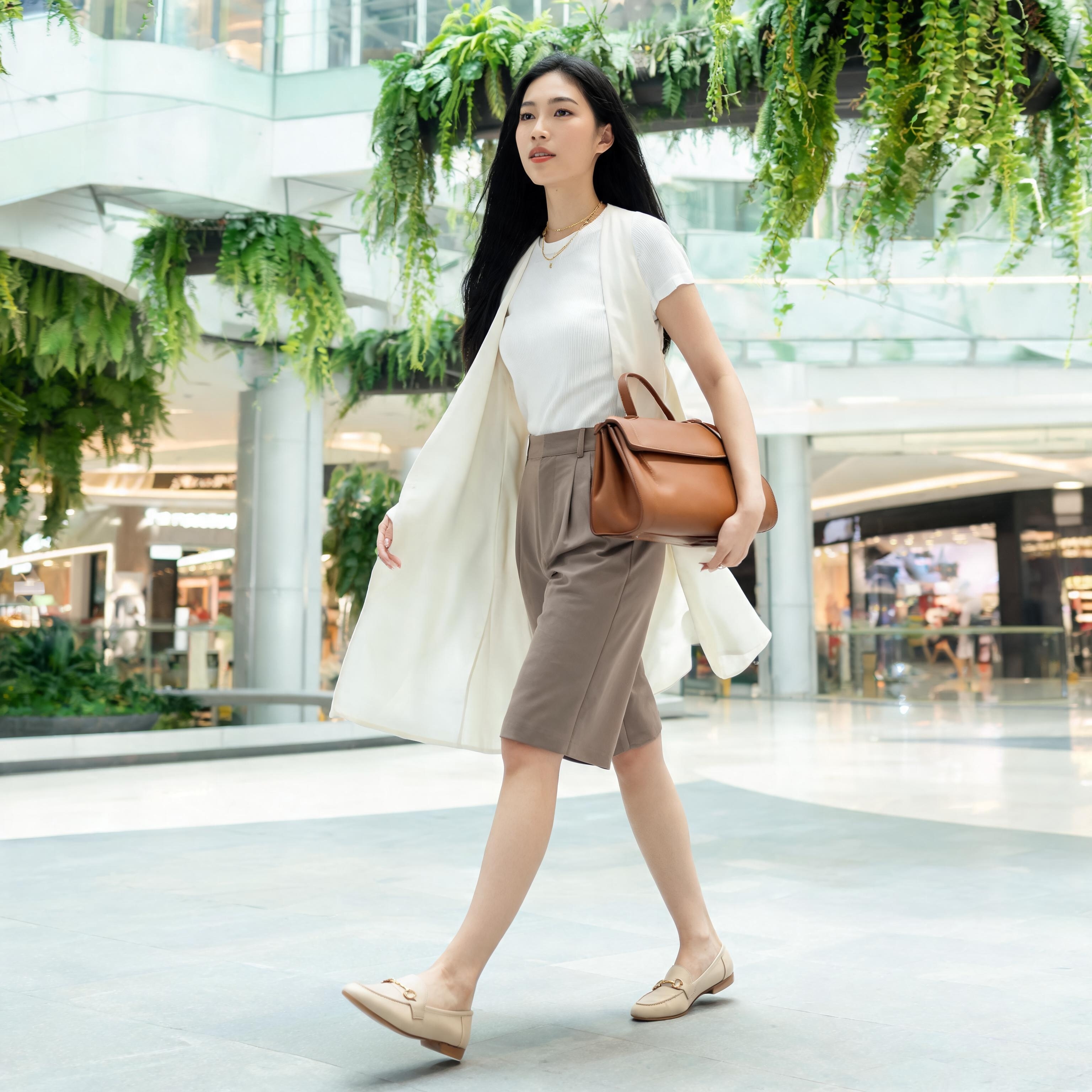 SKIPIKS AI 패션 화보 — modern, chic — 깨끗하고 세련된 무드가 돋보이는 모던룩이에요. 흰색 톱과 롱 베스트가 시원하면서도 고급스러움을 더해주며, 베이지 톤의 반바지와 로퍼가 안정감을 